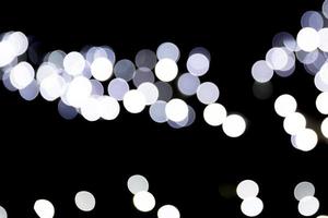 Abstract bokeh of white city lights on black background. defocused and blurred many round light photo