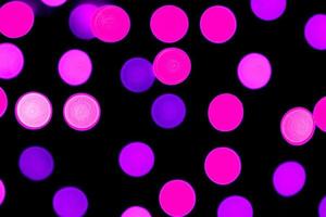 Bokeh púrpura abstracto desenfocado sobre fondo negro. desenfocado y borroso muchas luces redondas foto