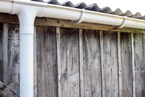 New rain gutter on a home against blue sky. New roof. photo