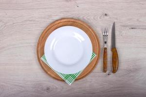 Empty Plate, Fork and Knife on wooden background. photo