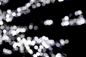 Unfocused abstract white bokeh on black background. defocused and blurred many round light photo