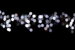 Abstract bokeh of white city lights on black background. defocused and blurred many round light photo