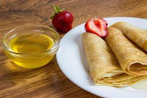 pila de crepes con jarabe de fresa y miel foto