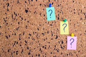 uncertainty or doubt concept, question mark on a sticky note on cork bulletin board photo