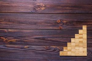 A wooden blocks cube over black wooden textured background with copy space for add word text title. Concept or conceptual Wood block stair or seven steps. Cubic photo