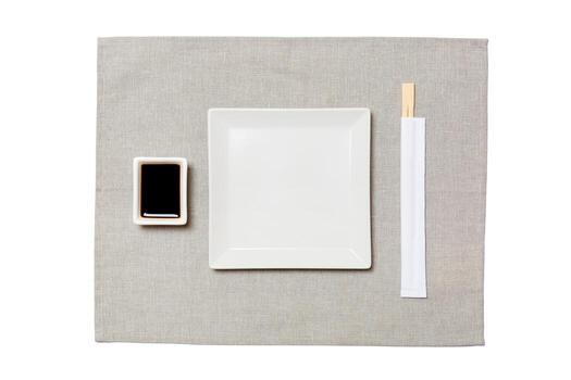 Empty white square plate with chopsticks for sushi and soy sauce on grey napkin background. Top view with copy space for you design photo