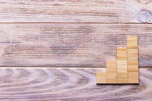 A wooden blocks cube over black wooden textured background with copy space for add word text title. Concept or conceptual Wood block stair or four steps. Cubic photo