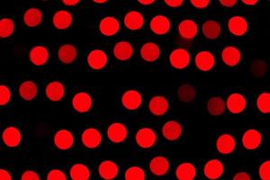 Bokeh rojo abstracto desenfocado sobre fondo negro. desenfocado y borroso muchas luces redondas foto