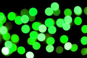 Unfocused abstract colourful bokeh black background. defocused and blurred many round green light photo