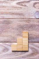 A wooden blocks cube over black wooden textured background with copy space for add word text title. Concept or conceptual Wood block stair or three steps. Cubic photo