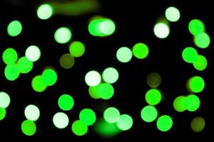 Unfocused abstract colourful bokeh black background. defocused and blurred many round green light photo