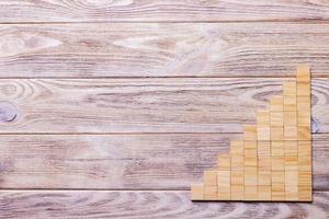 A wooden blocks cube over black wooden textured background with copy space for add word text title. Concept or conceptual Wood block stair or nine steps. Cubic photo