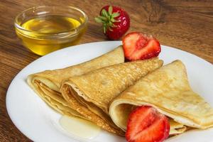 pila de crepes con jarabe de fresa y miel foto