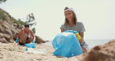 Mutter und Tochter sammeln Müll am Strand
