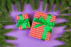 Top view of gift box and fir tree branches on colorful background. Merry Christmas concept with empty space for your design photo