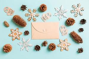 Top view of craft envelope, holiday toys and decorations on blue Christmas background. New Year time concept photo
