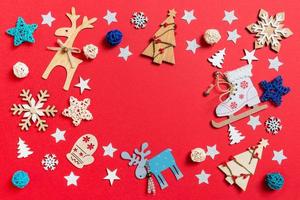 Top view of holiday toys and decorations on red Christmas background. New Year time concept with copy space photo