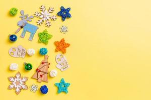 Top view of yellow background with New Year toys and decorations. Christmas time concept with copy space photo