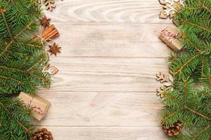 fondo de navidad con abeto y caja de regalo en la mesa de madera. vista superior con espacio de copia para su diseño foto