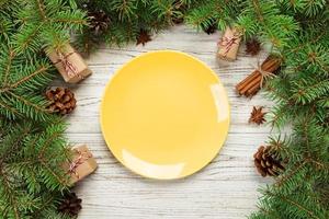 top view. Empty plate round ceramic on wooden christmas background. holiday dinner dish concept with new year decor photo