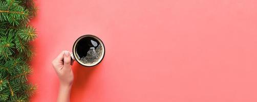 High angle of woman hands holding coffee mug on pink background Minimalistic style. Flat lay, banner top view isolated photo