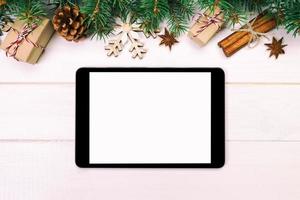 Digital tablet mock up with rustic Christmas wooden background decorations vintage, toned for app presentation. top view with copy space photo