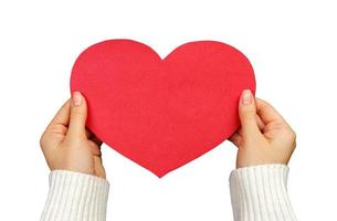 A close up of a female hand holding a red paper heart with copy space. Love and romance concept. Isolated on a white background photo