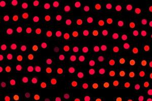 Unfocused abstract red bokeh on black background. defocused and blurred many round light photo