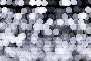 Abstract bokeh of white city lights on black background. defocused and blurred many round light photo