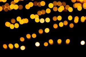 Festive abstract gold background with bokeh defocused and blurred many round yellow light on Christmas dark background photo