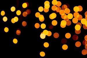 Unfocused abstract gold bokeh on black background. defocused and blurred many round light photo