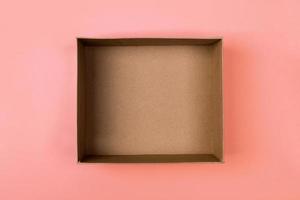 empty cardboard paper box on orange background. delivery concept, top view photo