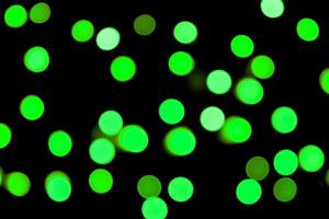 Unfocused abstract colourful bokeh black background. defocused and blurred many round green light photo