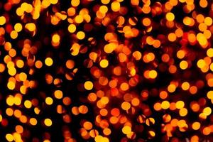 Unfocused abstract gold bokeh on black background. defocused and blurred many round light photo