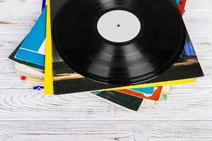 Pile of old vinyl records on wooden background photo