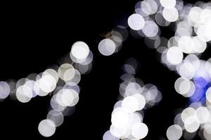 Unfocused abstract colourful bokeh with blue lamp on black background. defocused and blurred many round light photo