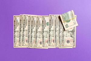 Top view of lying 10 dollar banknotes in one line on colorful background. Close up of money saving concept
