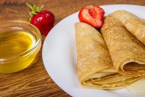 pila de crepes con jarabe de fresa y miel foto