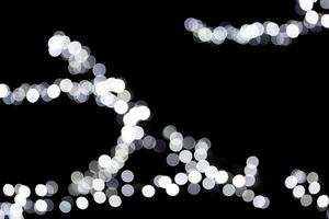 Abstract bokeh of white city lights on black background. defocused and blurred many round light photo