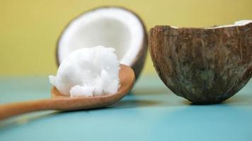 Wooden spoon with coconut oil next who open coconut fruits video