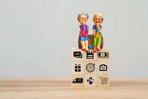 Elderly clay doll on wooden cube block. Retirement Planning Ideas, saving money, retirement, health care, business finance, shopping and travel. photo