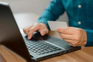Man uses a laptop to register through a credit card to make online purchases. Credit card safe online shopping and payment concept. photo