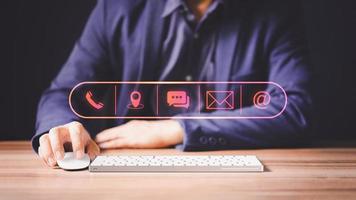 Businessman using a computer with the call phone, map, address, chat message and email icons. Customer support hotline contact us people connection concept. photo