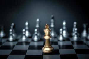 Golden King chess standing in front on board game. Concept leadership strategy business. photo