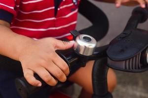 small hand handling bicycle bar. bike bell on bar . kid riding bicycle photo