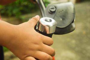 Close up of bicycle bell on handlebars and boy hand photo