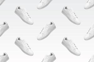 Pattern of white sneakers isolated on white background. Sportive pair of shoes for mockup. Fashionable stylish sports casual shoes. Modern and minimalist wallpaper of fashion lifestyle. photo