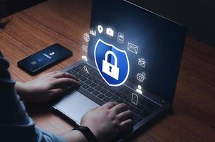 Woman checking laptop with digital security interface. Internet of things. Cybersecurity concept. Icon shield with lock symbol. Protection against dangers. photo