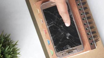 Wrecked screen of smartphone on spiral notebook video