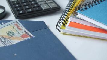 cuadernos calculadora lupa y dinero en efectivo en el escritorio video